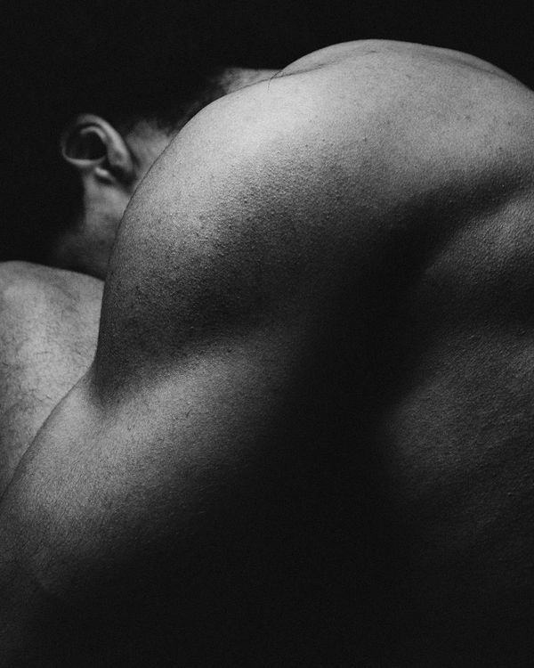 Athletic man in a dynamic pose against a dark background with emerald light.