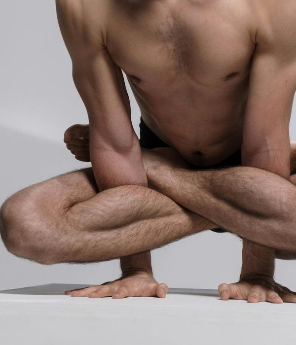 Man performing a focused bodyweight exercise in a minimalist setting.